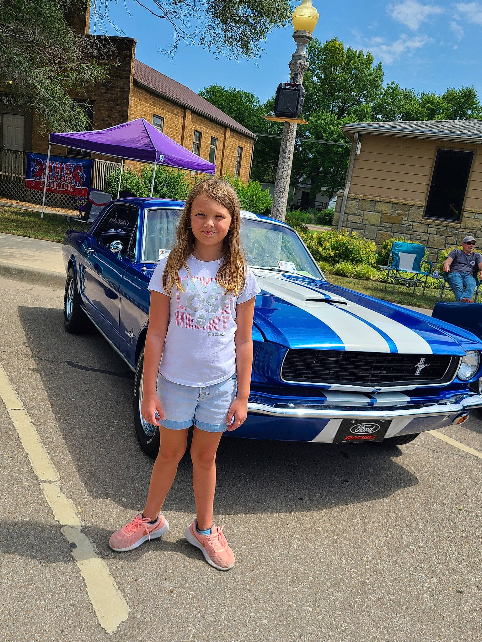 Haylie is registered to the contest to win money with this photo: automotive_design, automotive_exterior, automotive_lighting, automotive_wheel_system, bumper, car, clothing, headwear, hood, joy, land_vehicle, leisure, motor_vehicle, person, personal_luxury_car, sky, street_fashion, tire, tree, vehicle