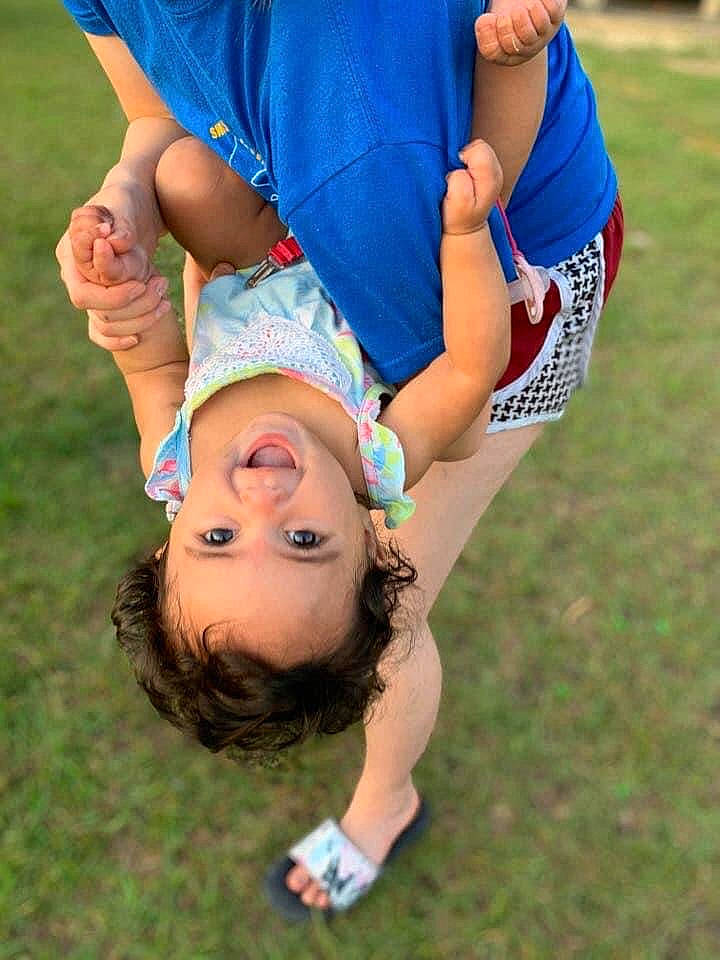 Korra is registered to the contest to win money with this photo: baby, baby_toddler_clothing, bracelet, gesture, hand, happy, people_in_nature, person, play, playing_with_kids, thumb, walking_shoe, wrist