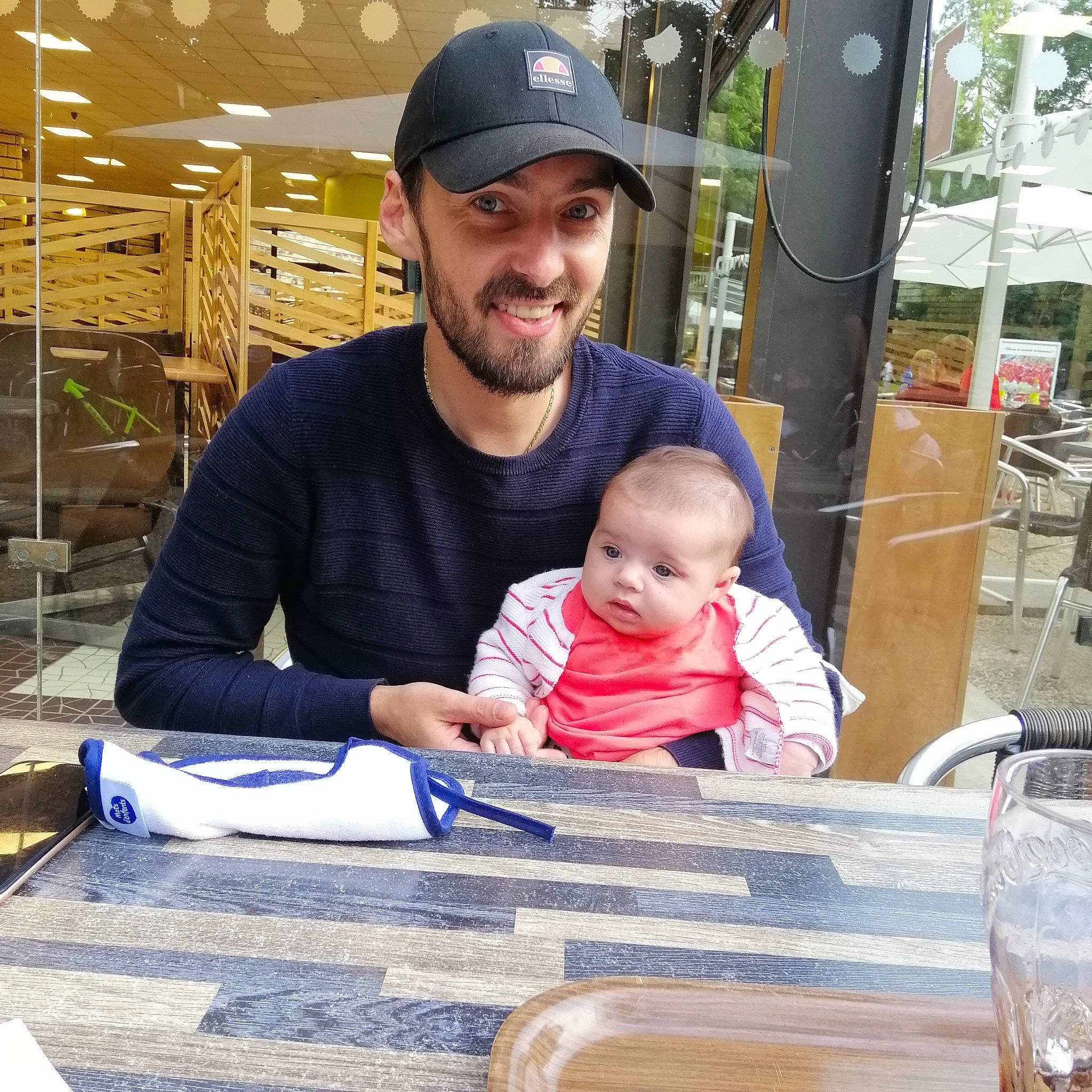 Juline a rejoint le concours — aidez-le/la à gagner de superbes lots ! baby, baby_products, baseball_cap, beard, cap, child, event, fun, happy, hat, headwear, joy, leisure, person, recreation, sitting, smile, t_shirt, table, tableware