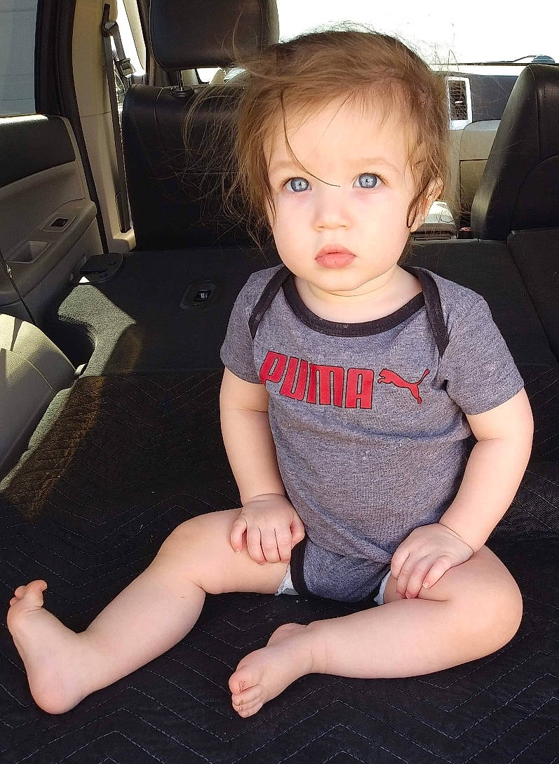 Niko is registered to the contest to win money with this photo: arm, auto_part, baby, car, car_seat, cheek, child, finger, hand, leg, luxury_vehicle, person, sitting, skin, thumb, toddler