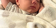 Cristian is registered to the contest to win money with this photo: baby, sleeping, blanket, polka_dot, infant, soft, cozy, face, peaceful, rest, bed, cute, child, wrapped, comfort, skin, head, hand, nap, indoors