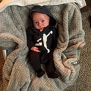 Cristian joined the competition — help win amazing prizes! baby, infant, hoodie, blanket, baby_carrier, carpet, footwear, sneaker, black_clothing, white_logo, indoor, person, face, cute, cozy, soft_texture, carpet_floor, lying_down, child, comfortable