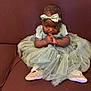 Fatoumata a rejoint le concours — aidez-le/la à gagner de superbes lots ! baby, child, tulle_dress, headband, bow, sitting, couch, brown_couch, sparkly_shoes, footwear, clothing, infant, cute, portrait, indoor, person, young_child, fashion, adorable, hands