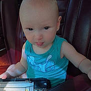 Christian joined the competition — help win amazing prizes! baby, child, car_seat, blue_shirt, wallet, leather_seat, tongue_out, curious, indoor, person, young_child, seat, vehicle, hand, face, portrait, casual_clothing, car_interior, daylight, expression