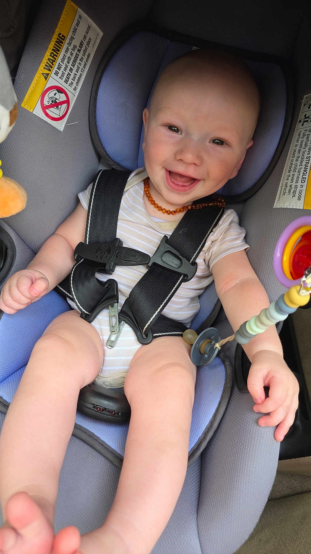 Christian is registered to the contest to win money with this photo: baby, car_seat, smiling, child, infant, seatbelt, onesie, toy, amber_necklace, happy, cute, sitting, indoors, safety, child_safety, person, face, head, limbs, closeup