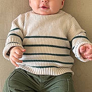 Thiago a rejoint le concours — aidez-le/la à gagner de superbes lots ! baby, child, infant, sweater, striped_clothing, green_pants, socks, couch, furniture, indoor, portrait, smiling, happy, cute, face, head, person, clothing, seated, young