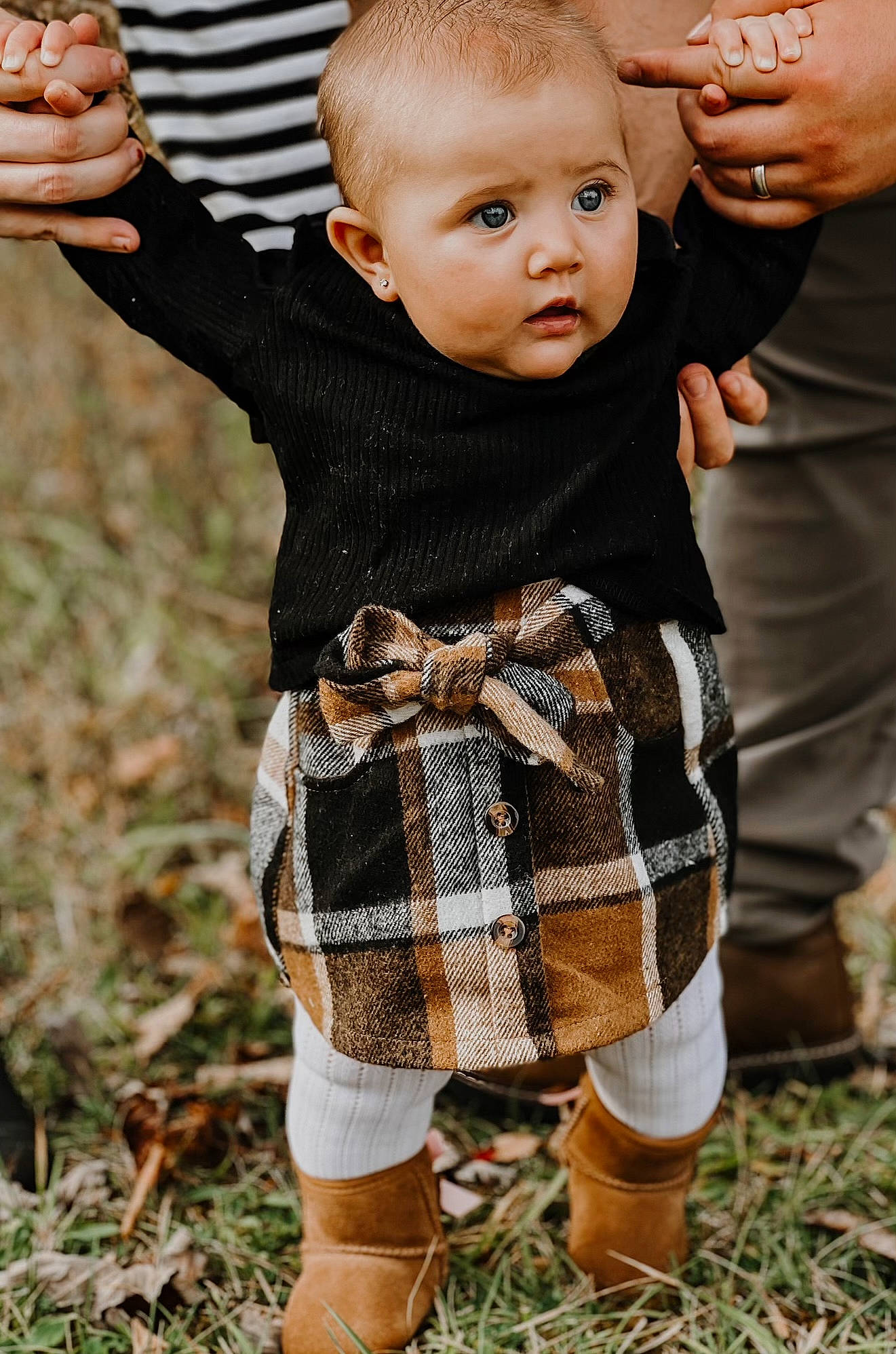Macie is registered to the contest to win money with this photo: baby, baby_toddler_clothing, child, eye, face, finger, gesture, grass, hand, happy, head, pattern, people_in_nature, person, plaid, plant, skin, sleeve, surprise, tartan