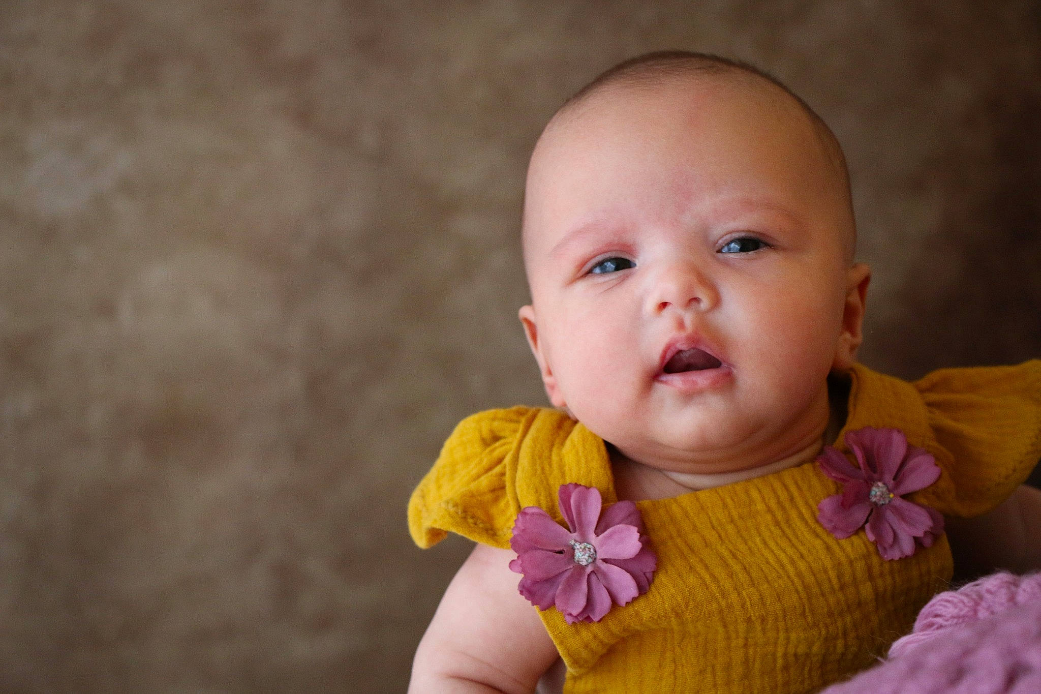 Clémence participe au concours pour gagner de l'argent avec cette photo : arm, baby, baby_toddler_clothing, cheek, chin, dress, eye, face, finger, hand, happy, headgear, iris, lip, neck, nose, outerwear, person, petal, plant