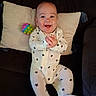 Jeremiah is registered to the contest to win money with this photo: baby, infant, smile, clapping, onesie, stars, pillow, couch, toy, colorful, happy, child, indoor, face, person, footed_pajamas, sitting, cute, playful, young