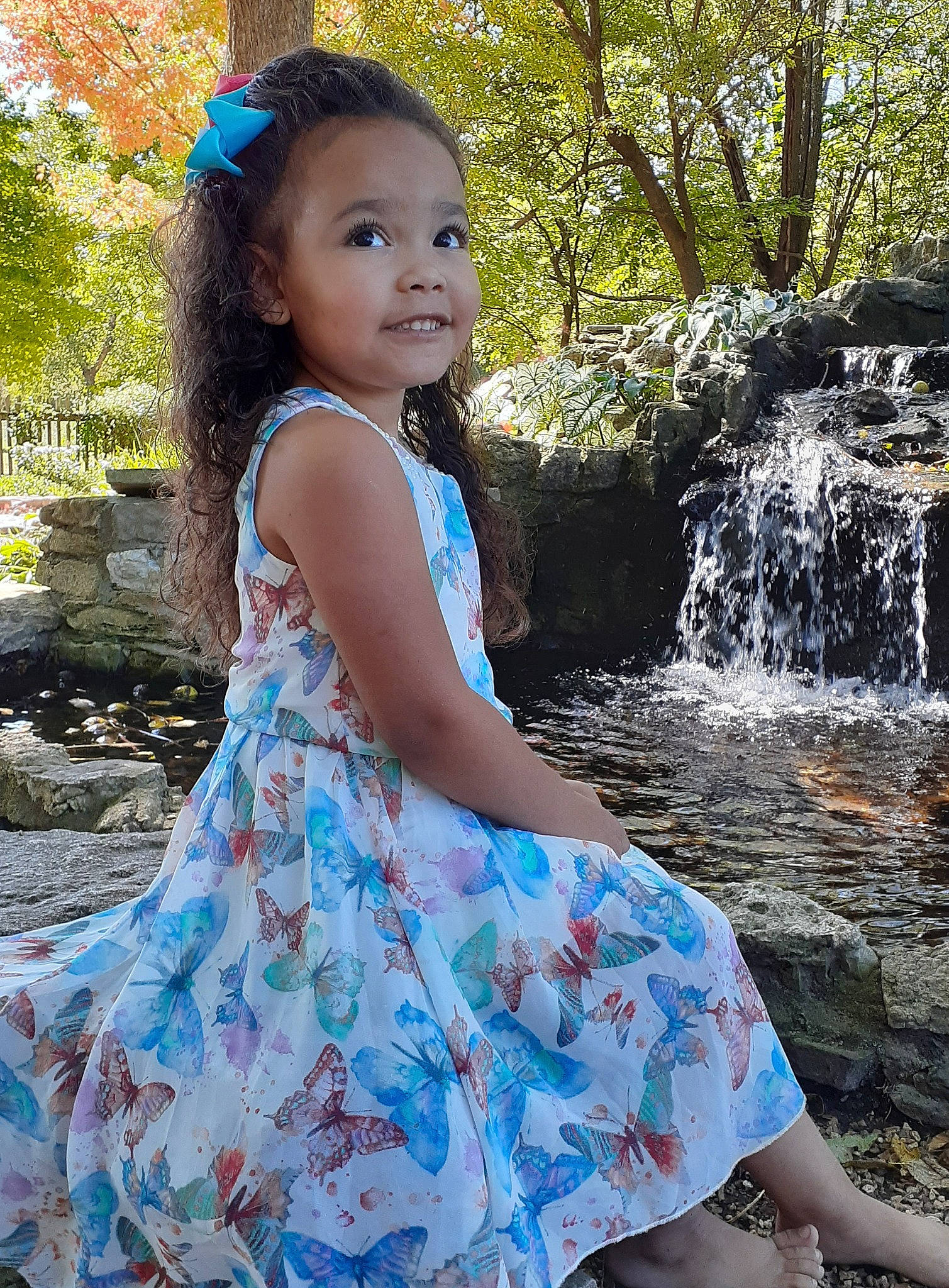 Emmie is registered to the contest to win money with this photo: baby_toddler_clothing, beauty, child, child_model, clothing, creek, day_dress, dress, foot, hair_accessory, headband, headpiece, one_piece_garment, person, spring, stream, summer, toddler, water_feature, waterfall