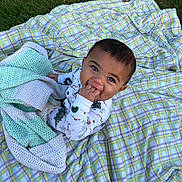 Eli joined the competition — help win amazing prizes! baby, child, blanket, grass, outdoor, plaid, knitted_blanket, cute, infant, sitting, hand_in_mouth, clothing, pattern, green, purple, white, nature, happy, portrait, toddler