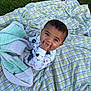 baby, child, blanket, grass, outdoor, plaid, knitted_blanket, cute, infant, sitting, hand_in_mouth, clothing, pattern, green, purple, white, nature, happy, portrait, toddler