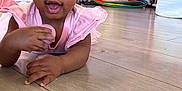 Taelor Burch joined the competition — help win amazing prizes! baby, child, pink_dress, toy, floor, wooden_floor, indoor, basket, hula_hoops, playful, happy, smiling, girl, earrings, pastel_colors, furniture, flooring, crawling, person, toddler