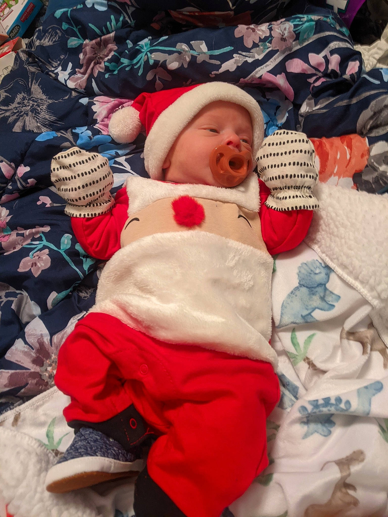 Eoghan is registered to the contest to win money with this photo: baby, baby_toddler_clothing, cap, carmine, child, comfort, event, fictional_character, fun, fur, happy, hat, headgear, headwear, leisure, linens, person, room, santa_claus, textile
