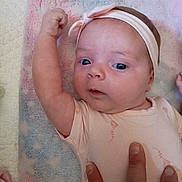 Lilyrose joined the competition — help win amazing prizes! baby, infant, face, blue_eyes, headband, pink, arm, fist, hand, blanket, pastel_colors, clothing, cute, portrait, child, skin, newborn, lying_down, person, soft_texture