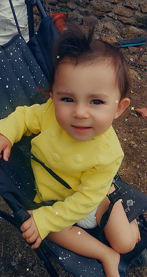 Inaya participe au concours pour gagner de l'argent avec cette photo : baby_toddler_clothing, cheek, chin, cool, eye, facial_expression, fun, gesture, grass, hair, hairstyle, happy, head, iris, joy, organ, person, public_space, skin, sleeve