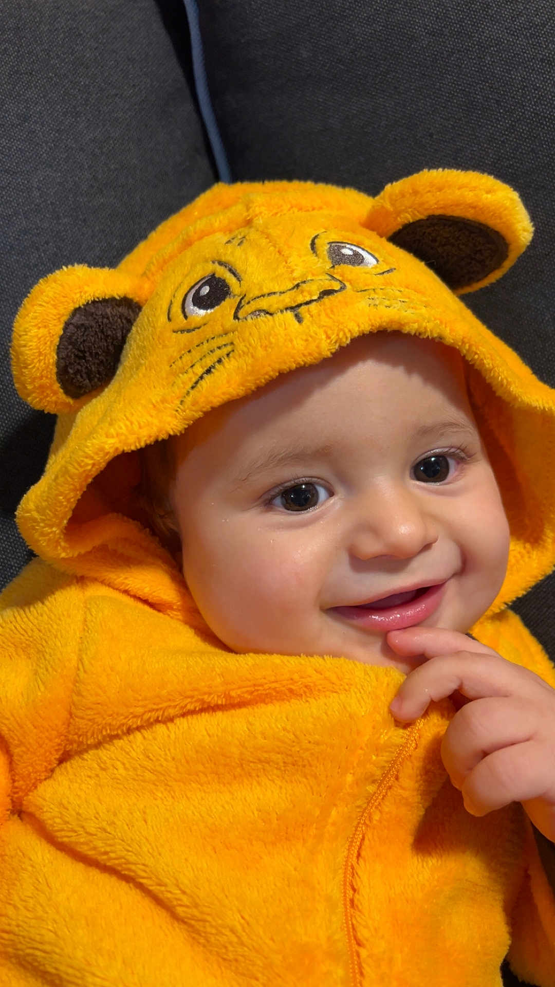 Kleos a rejoint le concours — aidez-le/la à gagner de superbes lots ! baby, child, smiling, yellow_costume, hood, lion_face, fuzzy_texture, cute, portrait, happy, hand, finger, animal_ears, costume, infant, face, clothing, indoor, soft, cozy