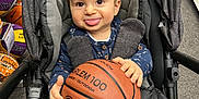 Kleos a rejoint le concours — aidez-le/la à gagner de superbes lots ! baby, basketball, basketball_rack, carpet_floor, child, clothing, face, gray_blanket, hand, indoor, person, playful, seated, shoe_boxes, smiling, sports_store, store, stroller, toddler, tongue_out