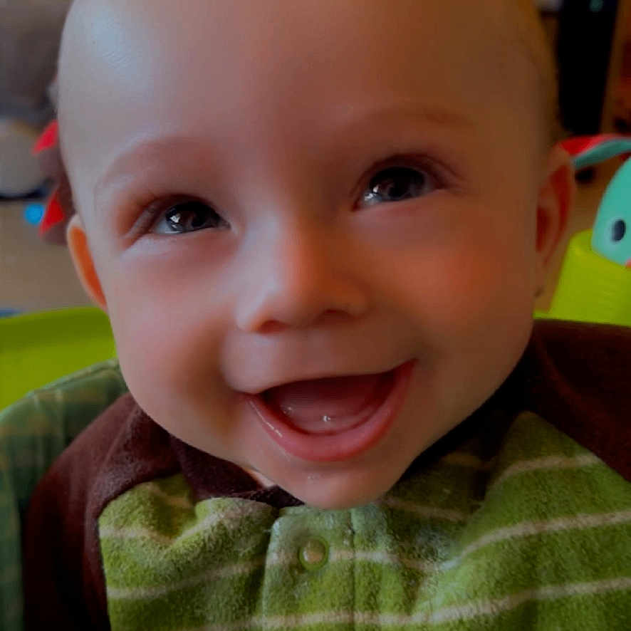 Jaxson is registered to the contest to win money with this photo: baby, bodypart, clothing, couch, face, finger, furniture, hand, happy, head, knitwear, laughing, mouth, newborn, person, photography, portrait, smile, sweater, teeth