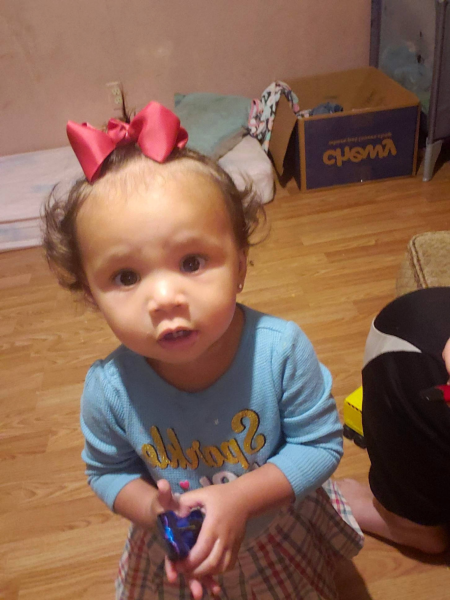 Londynn is registered to the contest to win money with this photo: baby, baby_toddler_clothing, child, costume_hat, ear, fashion_accessory, flooring, fun, happy, hardwood, headband, headpiece, lap, person, room, shipping_box, sitting, skin, t_shirt, toddler