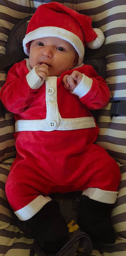 Eden a rejoint le concours — aidez-le/la à gagner de superbes lots ! baby, baby_toddler_clothing, cheek, child, drinkware, face, facial_expression, finger, hand, hat, headwear, jacket, lip, mouth, outerwear, person, pink, red, skin, sleeve