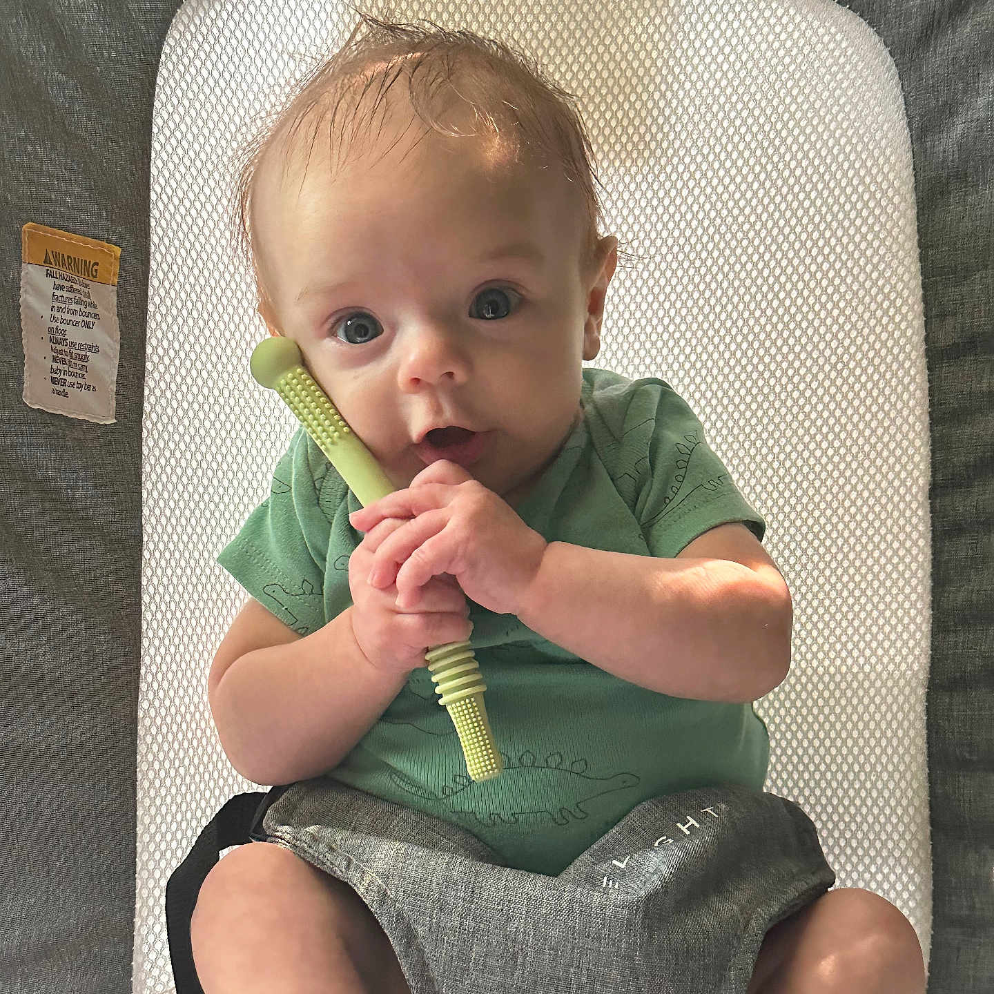 Parker is registered to the contest to win money with this photo: baby, biting, bodypart, brush, chair, clothing, device, eating, face, finger, food, furniture, head, person, photography, portrait, sitting, sleeve, tool, toothbrush