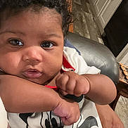Alani joined the competition — help win amazing prizes! baby, child, curly_hair, mickey_mouse, shirt, hand, face, eyes, indoor, kitchen, cabinet, floor, person, cute, infant, portrait, expression, clothing, holding, home