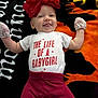 baby, infant, smiling, red_flower_headband, mittens, white_onesie, red_pants, tongue_out, lying_down, colorful_blanket, halloween_theme, orange, black, yellow, cute, child, portrait, happy, playful, indoors