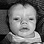 baby, infant, face, close_up, black_and_white, blanket, curly_hair, expression, couch, texture, person, portrait, young_child, indoors, clothing, cute, small_hand, striped_shirt, skin, eyes
