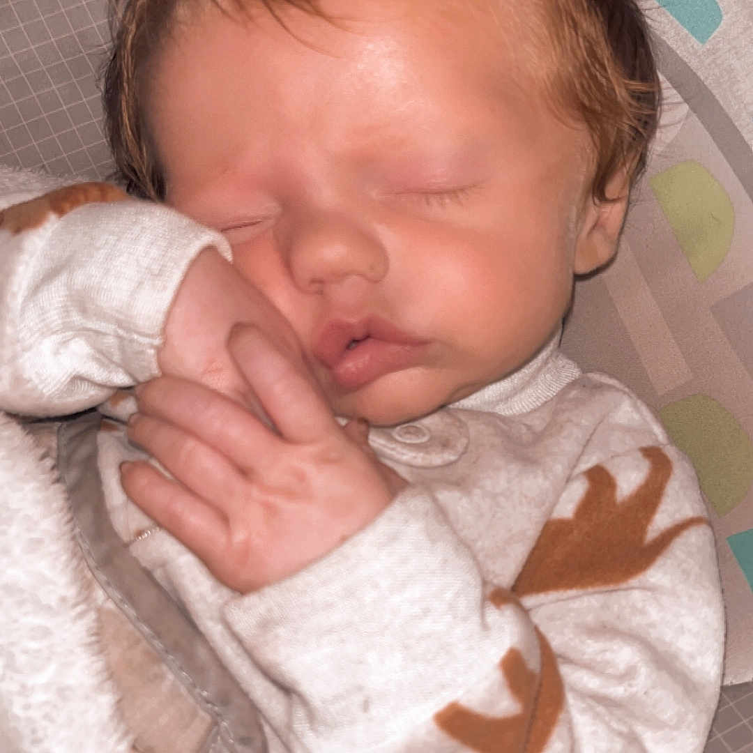 Jaydean is registered to the contest to win money with this photo: baby, blanket, child, closeup, comfort, cozy, cute, face, hand, indoors, infant, newborn, onesie, pattern, peaceful, portrait, rest, seat, sleeping, soft