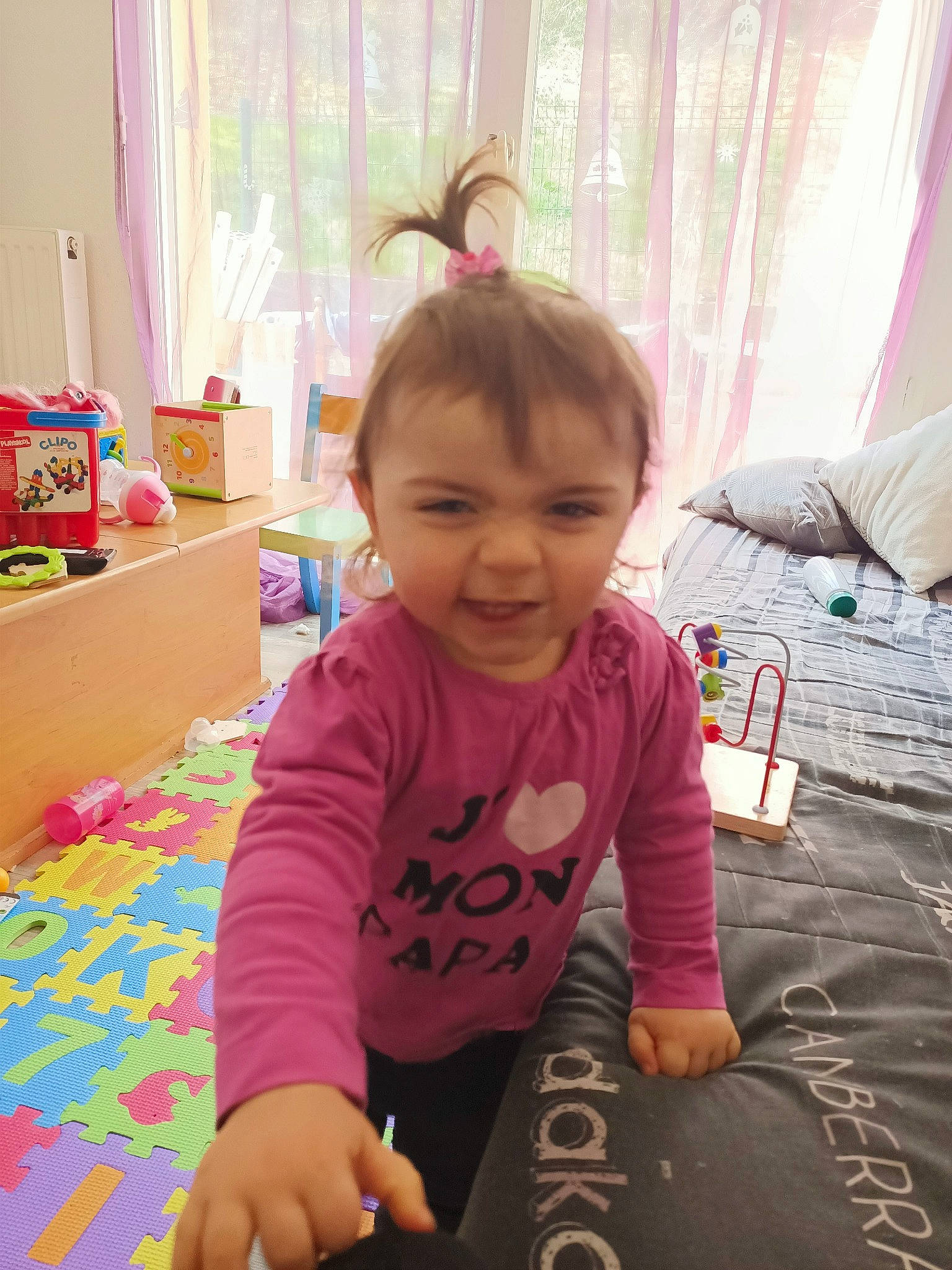 Lyne participe au concours pour gagner de l'argent avec cette photo : baby, baby_toddler_clothing, chair, child, curtain, flooring, fun, happy, leisure, magenta, person, pink, play, room, sitting, skin, smile, t_shirt, thumb, toddler