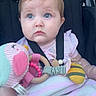 baby, child, car_seat, blue_eyes, toy, blanket, pink_clothing, soft_toy, seatbelt, infant, cute, portrait, indoor, sitting, person, childhood, comfort, expression, closeup, young