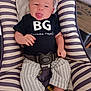 baby, infant, child, smiling, tongue_out, striped_clothing, black_shirt, striped_pants, baby_seat, cushion, indoor, playful, happy, person, seatbelt, comfortable, cute, head, face, feet