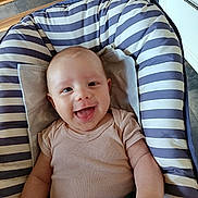 Eliott participe au concours pour gagner de l'argent avec cette photo : arm, baby, baby_seat, cabinet, child, clothing, comfort, cushion, face, floor, happy, head, indoor, infant, onesie, person, portrait, skin, smiling, striped