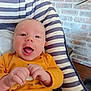 Eliott a rejoint le concours — aidez-le/la à gagner de superbes lots ! baby, infant, child, smiling, happy, orange_clothing, striped_cushion, seat, indoor, brick_wall, hands, face, expression, comfort, cute, young, portrait, person, head, playful