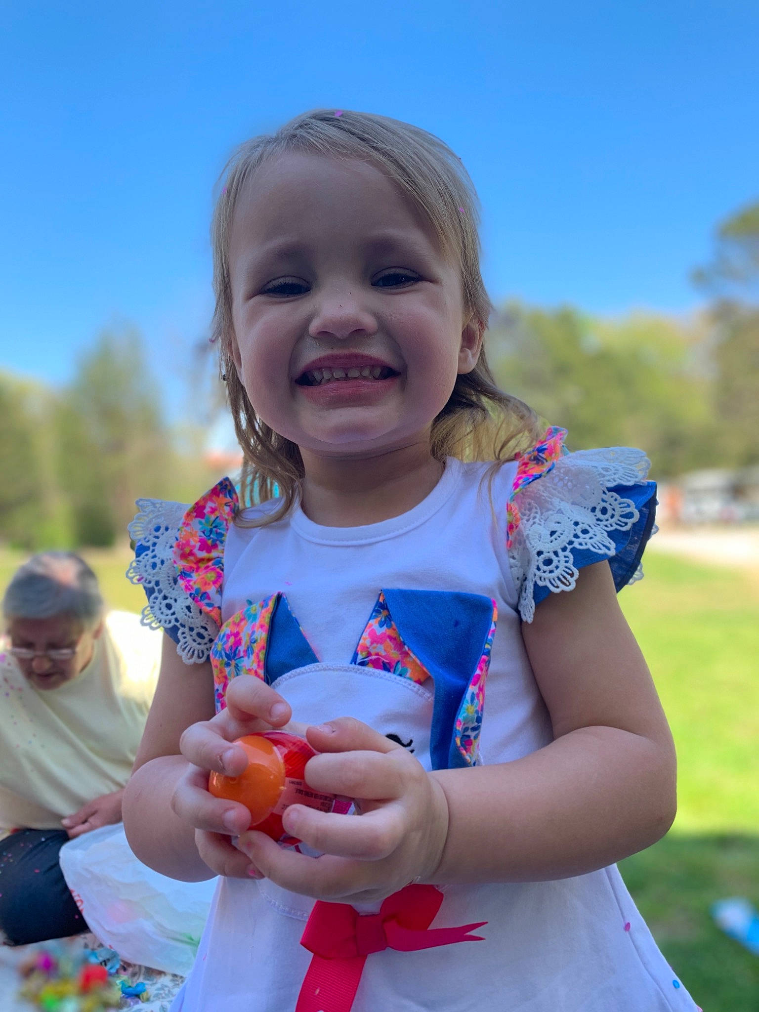 Madyson is registered to the contest to win money with this photo: arm, baby_toddler_clothing, facial_expression, finger, gesture, grass, hand, happy, iris, joy, leisure, people, people_in_nature, person, pink, plant, recreation, skin, sky, smile
