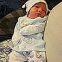 Greyson is registered to the contest to win money with this photo: baby, newborn, pajamas, hat, bottle, hand, blanket, cushion, indoor, person, infant, footwear, carpet, pattern, clothing, sleepwear, cute, relaxing, resting, home