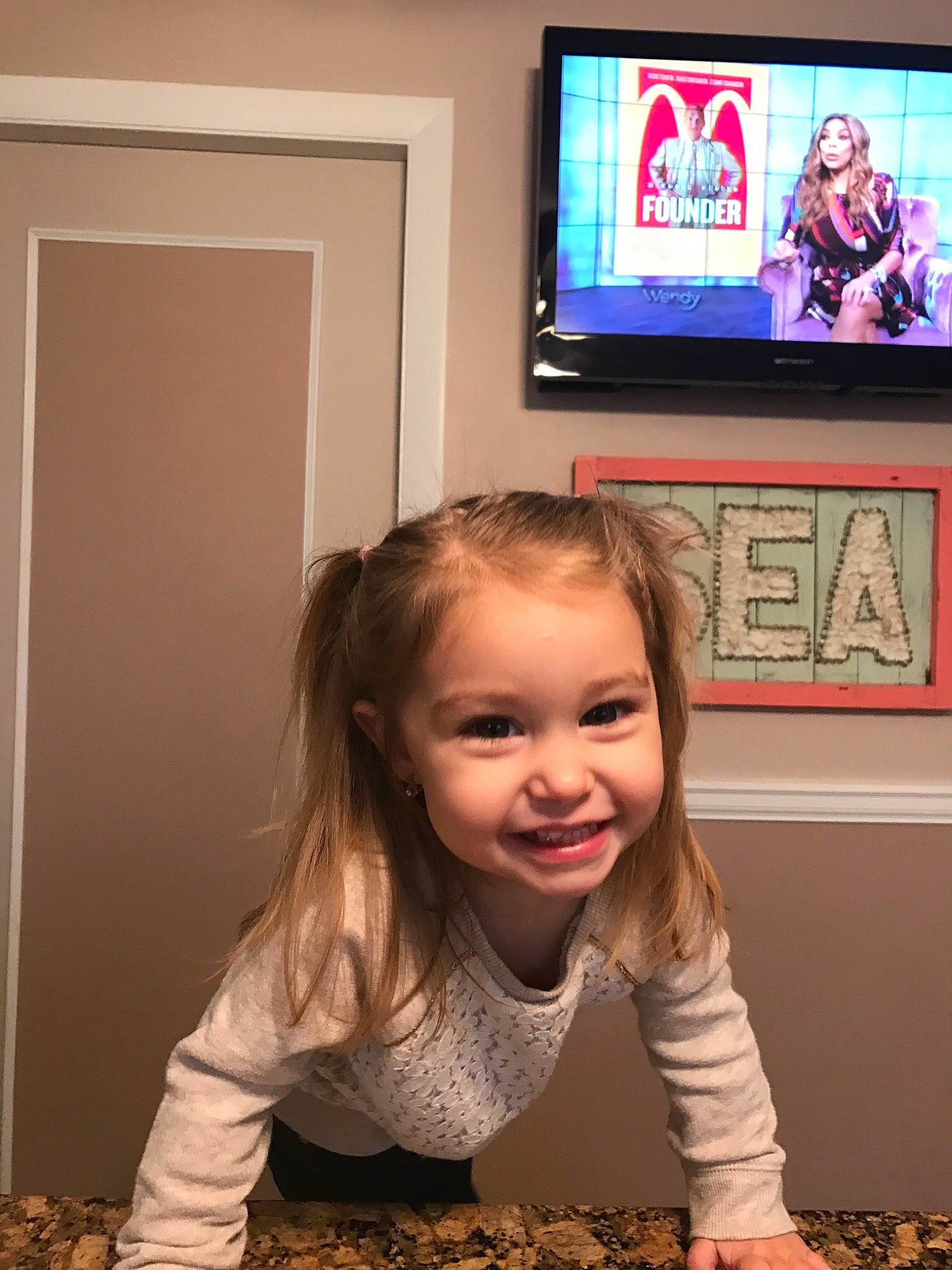 Coral is registered to the contest to win money with this photo: child, electronic_device, fun, joy, media, person, room, smile, technology, television, toddler