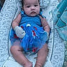 baby, infant, blue_dress, mittens, space_theme, baby_seat, curly_hair, chubby_cheeks, relaxed, indoor, portrait, cute, child, stars, planets, patterned_fabric, soft_toys, toddler, seated, colorful