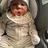 Catalina joined the competition — help win amazing prizes! baby, infant, pacifier, onesie, hat, car_seat, child, cute, clothing, sitting, face, person, indoor, newborn, comfort, soft, white, gloves, bib, expression