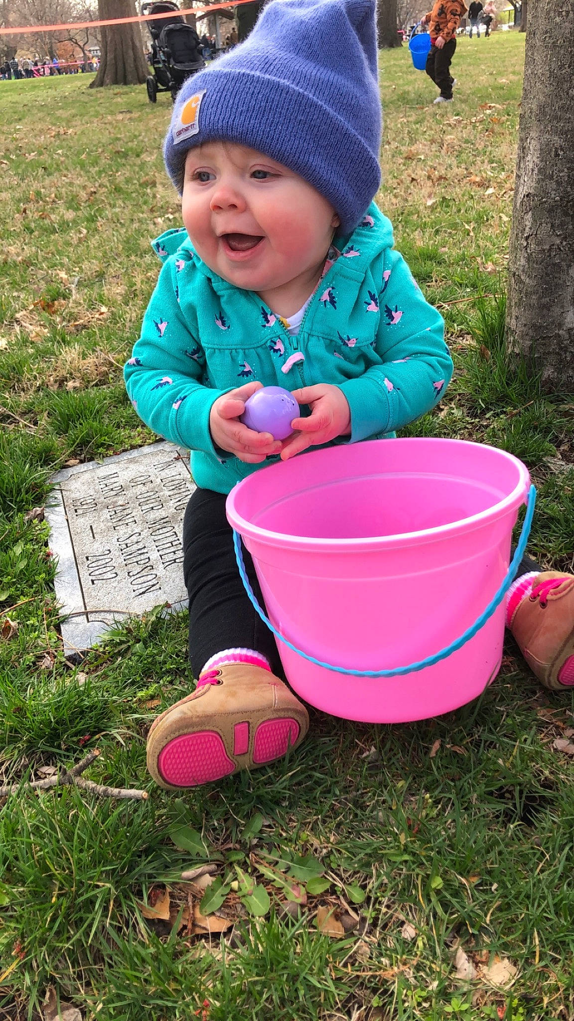 Hazley is registered to the contest to win money with this photo: baby, baby_toddler_clothing, bucket, child, easter, fun, grass, happy, headwear, hoodie, leisure, magenta, people_in_nature, person, pink, plant, play, recreation, smile, soil