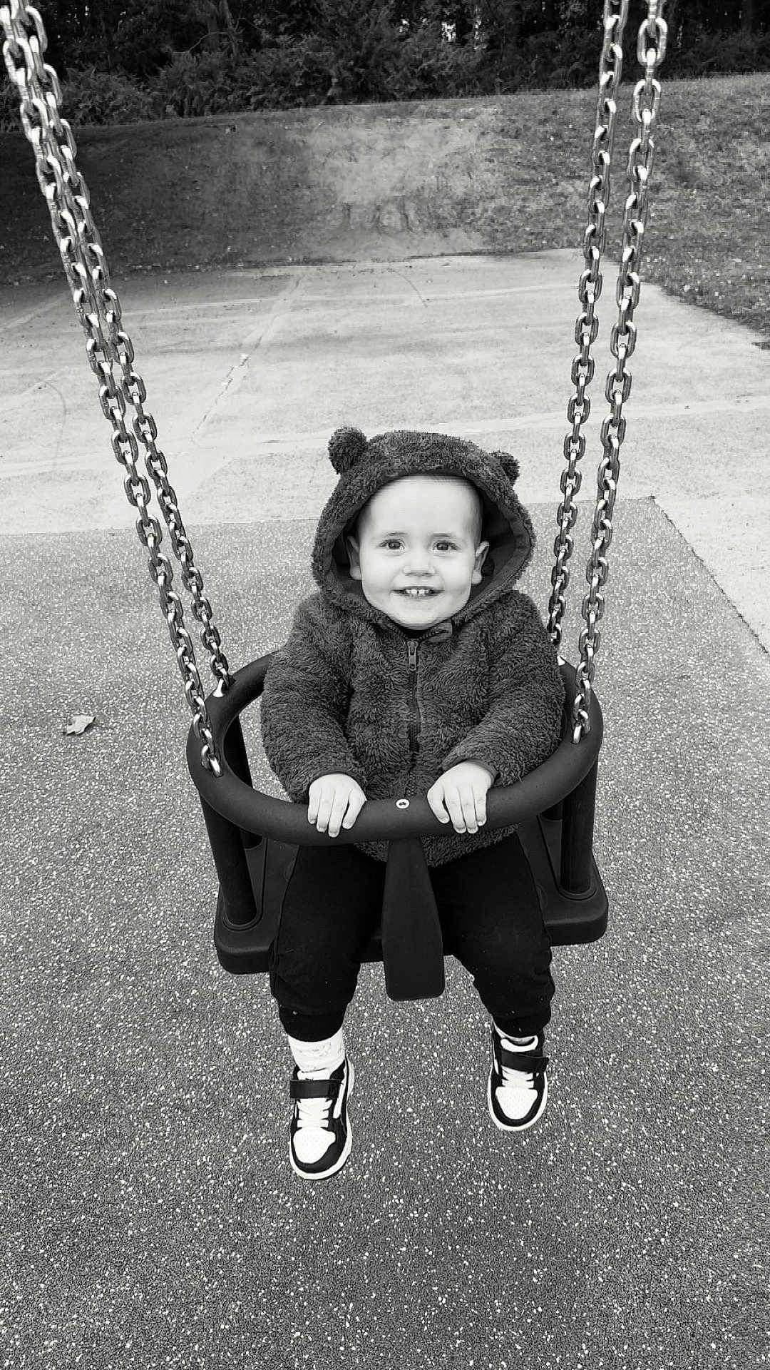 Owen participe au concours pour gagner de l'argent avec cette photo : toddler, child, swing, playground, hoodie, smile, happy, outdoor, park, chains, sneakers, black_and_white, baby_swing, cute, clothing, person, fun, seat, sitting, casual
