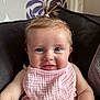 Arabella joined the competition — help win amazing prizes! baby, child, smiling, blue_eyes, pink_bib, pink_clothing, pony_tail, cushion, chair, indoor, wallpaper, pattern, face, happy, skin, person, portrait, seated, infant, cute