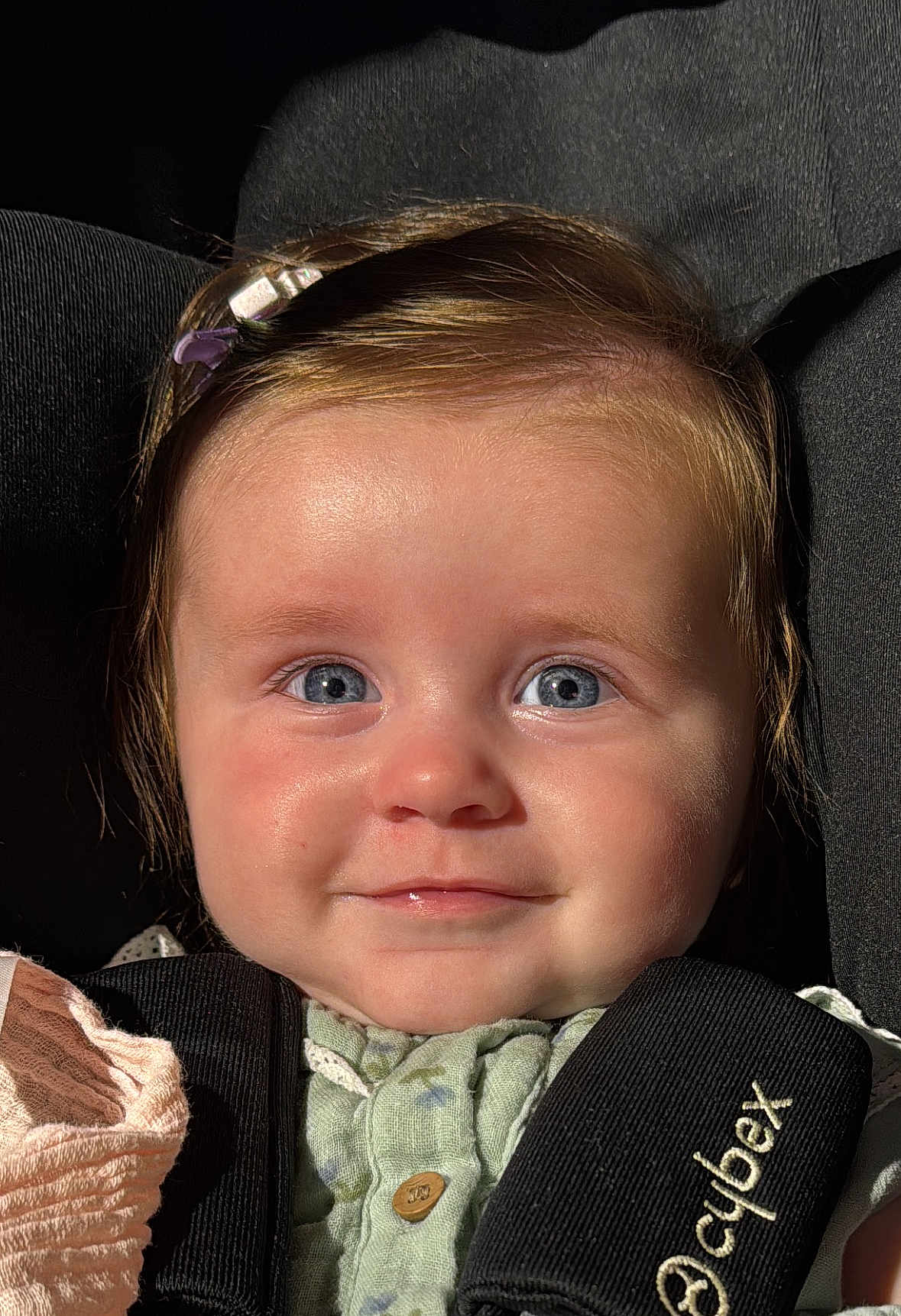 Arabella joined the competition — help win amazing prizes! baby, child, face, blue_eyes, smile, car_seat, safety_harness, hair_clip, close_up, portrait, infant, cute, soft_lighting, skin, clothing, seat, child_safety, young, person, happy