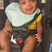 Zion is registered to the contest to win money with this photo: baby, bodypart, car, clothing, cushion, face, finger, hand, happy, head, homedecor, person, photography, portrait, shorts, sitting, smile, t_shirt, transportation, vehicle
