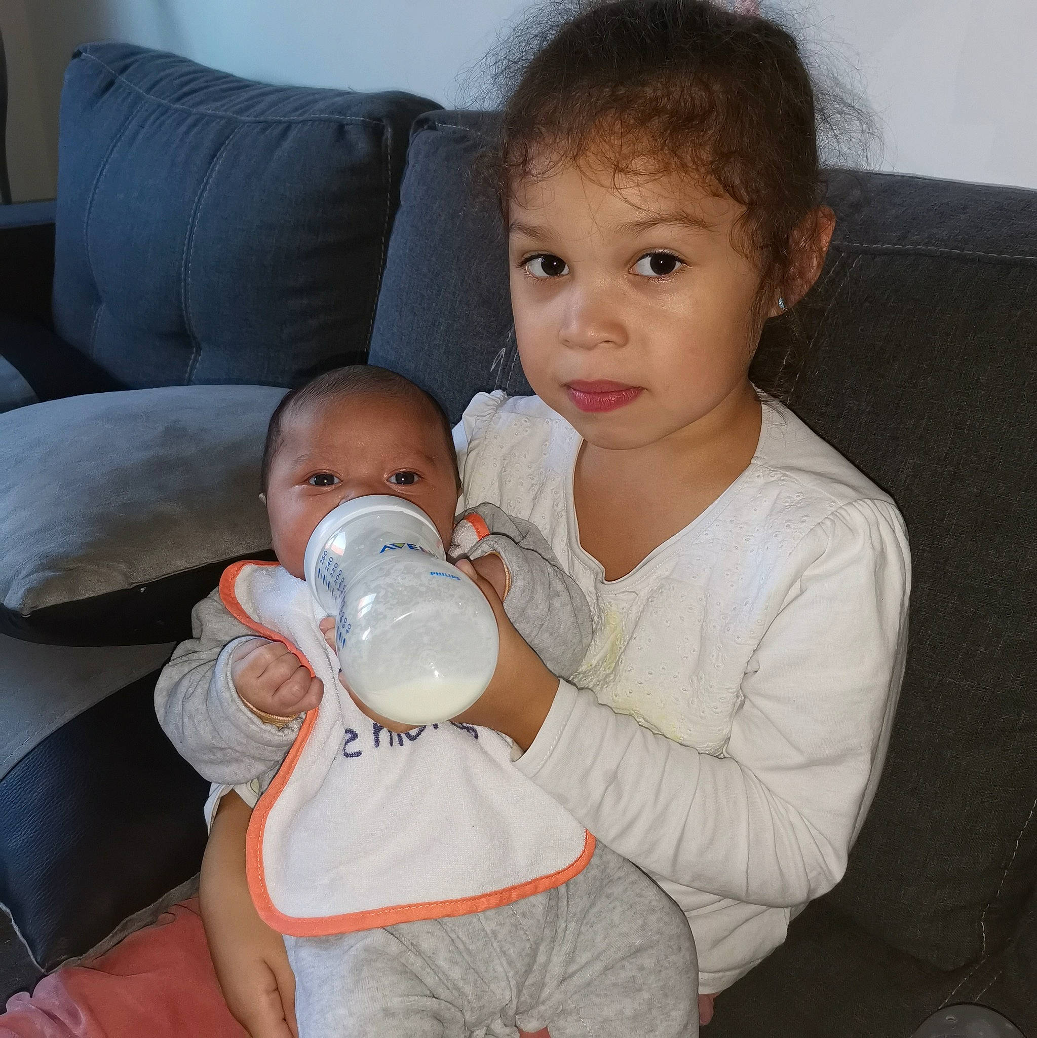 Léïa a rejoint le concours — aidez-le/la à gagner de superbes lots ! baby, baby_bottle, baby_toddler_clothing, bottle, cheek, child, comfort, couch, drinking, drinkware, ear, infant_formula, milk, mouth, neck, person, plant_milk, plastic_bottle, skin, toddler