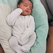 Deetya is registered to the contest to win money with this photo: baby, newborn, sleeping, infant, white_clothing, onesie, cushion, soft_texture, comfort, peaceful, resting, closeup, indoor, person, child, cute, small, head, face, human