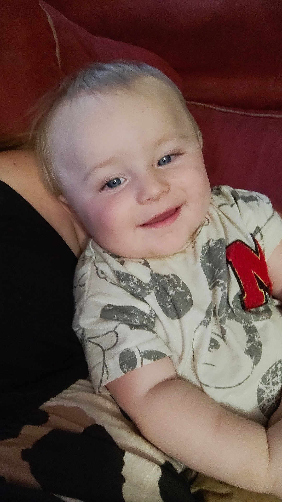 James joined the competition — help win amazing prizes! child, toddler, smiling, blue_eyes, short_hair, patterned_shirt, sitting, indoor, close_up, cute, happy, person, face, skin, arm, couch, red_background, casual_clothing, comfort, young