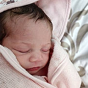 Aspen is registered to the contest to win money with this photo: baby, newborn, wrapped, pink_towel, sleeping, face, skin, infant, cute, soft_texture, blanket, closeup, peaceful, head, portrait, indoors, hair, rest, child, cozy