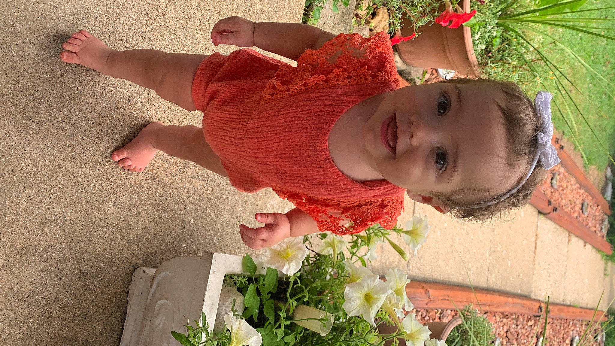 Fallon is registered to the contest to win money with this photo: baby, baby_toddler_clothing, child, cut_flowers, event, facial_expression, flower, flower_arranging, fun, grass, green, happy, hat, joy, people_in_nature, person, petal, plant, red, smile